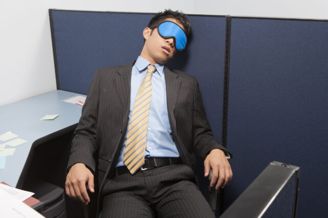 Man sleeping in the office using eyemask